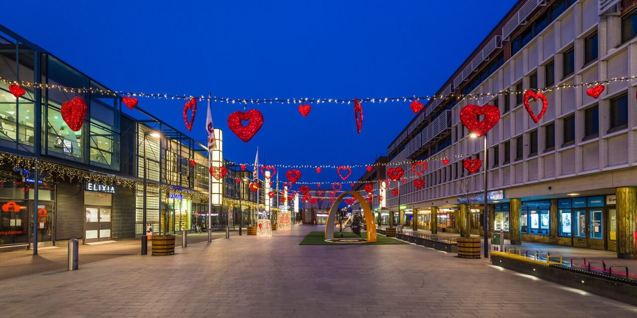 Upphängda röda hjärtan tillsammans med ljusslingor.